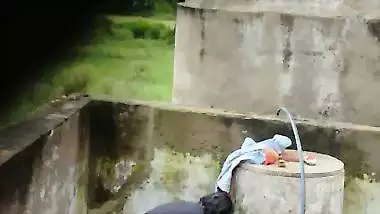 Indian village girl bathing near water tank outdoor